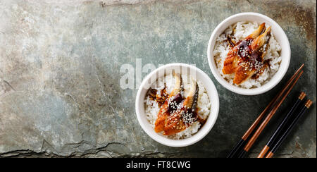 Eel on Rice with sauce and sesame served for two on stone slate background Stock Photo