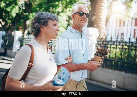 Senior man and woman walking in the city. Mature tourist roaming in a town during their vacation. Stock Photo