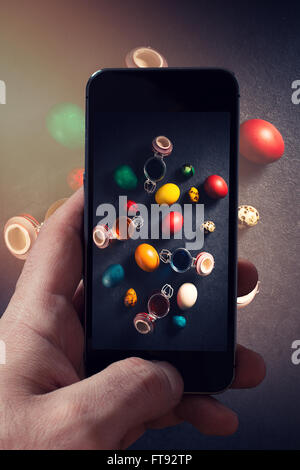 Man photographing colorful Easter eggs from above on dark background Stock Photo