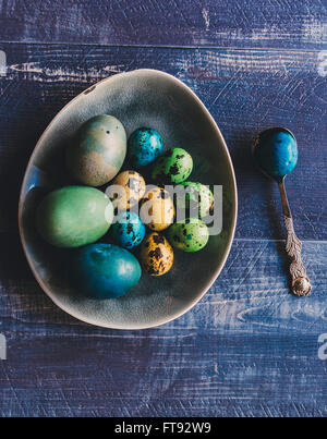 Colorful Easter eggs in the plate on wooden background w Stock Photo