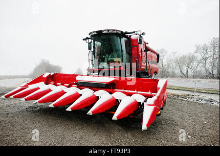 New red combine harvester at snowy weather Stock Photo