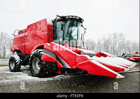 New red combine harvester at snowy weather Stock Photo