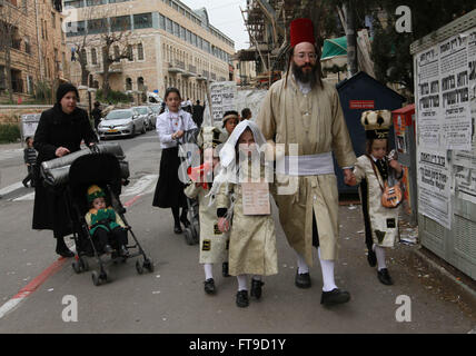 Jerusalem. 25th Mar, 2016. An Ultra-Orthodox Jewish family walk in a street during celebrations for the Purim Festival in Jerusalem's Mea Shearim neighbourhood, on March 25, 2016. Purim is a celebration of the Jews' salvation from genocide in ancient Persia, as recounted in the Book of Esther. Credit:  Gil Cohen Magen/Xinhua/Alamy Live News Stock Photo