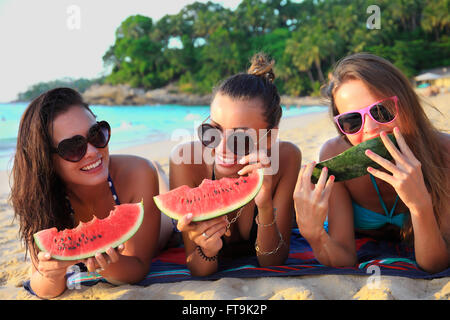 Happy smiling female friends lying on tropical beach Stock Photo