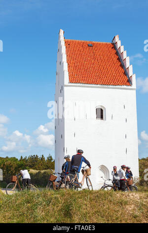 Youths on bicycle ride to Sand-Covered Church in Skagen Stock Photo