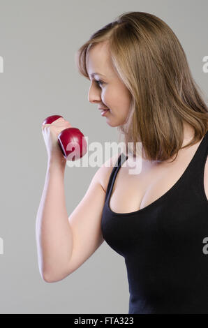 Beautiful young woman working out with dumbbells Stock Photo