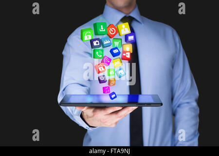 Businessman holding a tablet pc with mobile applications icons on virtual screen . Internet and business concept. Stock Photo