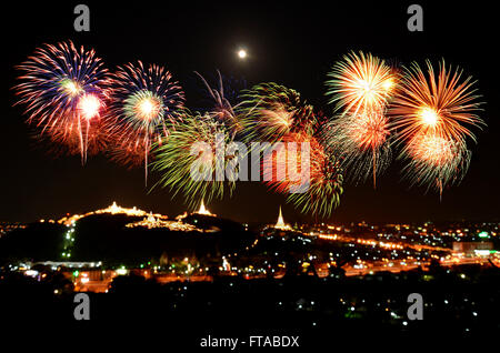 Colorful fireworks celebration and the city night light background. Stock Photo