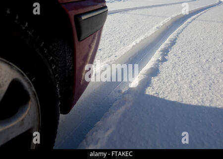 Car tyre tracks left in a deep layer of snow creating an abstract pattern like a river winding through the countryside. Stock Photo