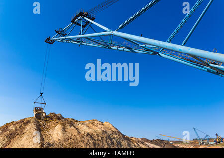 huge walking excavator bucket on blue sky background Stock Photo