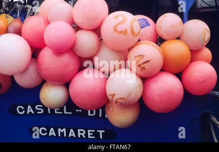 Pink buoys for fishing at the stern of a blue fishing boat in the port of Camaret,Brittany,France Stock Photo