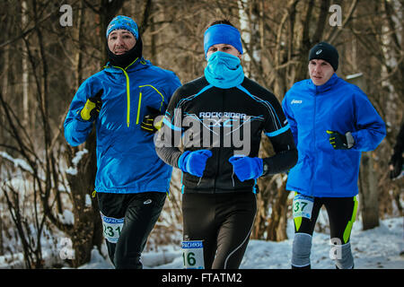 Ekaterinburg, Russia - November 14, 2015: group of young male athletes running together on a snowy Park in December Stock Photo