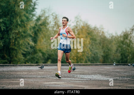 Omsk, Russia -  September 20, 2015: young runner runs along river during Siberian international marathon Stock Photo