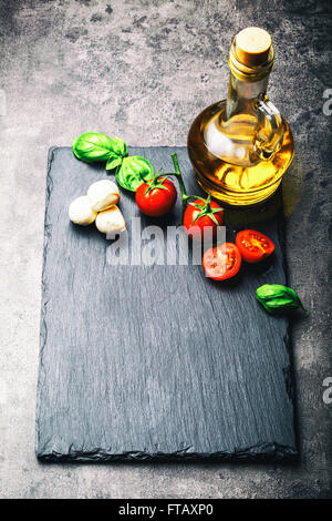 Tomatoes. Cherry tomatoes. Cocktail tomatoes. Fresh grape tomatoes carafe with olive oil on table. Toned photo Stock Photo