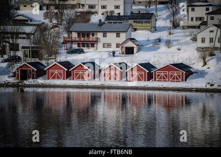 Red boat houses at the side of a fjord near Tromso, Norway. Stock Photo