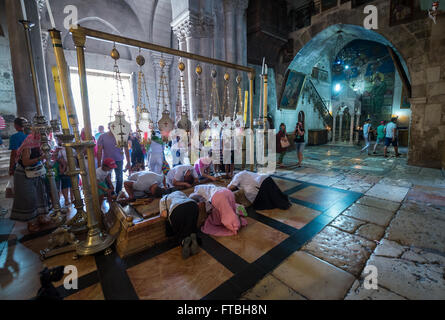 Pilgrims praying next to Stone of Anointing (also Stone of Unction) in Church of Holy Sepulchre, Old Town of Jerusalem, Israel Stock Photo