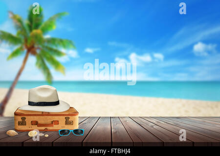 Hat, passenger suitcase, sunglasses, shell on beach table. Free space for text. Beach, sea, palm and blue sky in background. Stock Photo