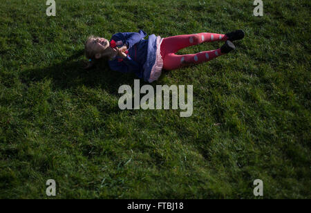 Young girl rolling down the hill Stock Photo - Alamy