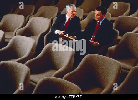 Two corporate business leaders seated in large conference room Stock Photo