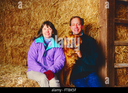 Environmental portrait in a barn of Photographer H. Mark Weidman; writer Marjorie Ackermann; and their Golden Retriever; Chelsea Stock Photo