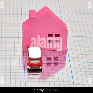 A pink house with a car parked in front on a blue squared shiny surface Stock Photo