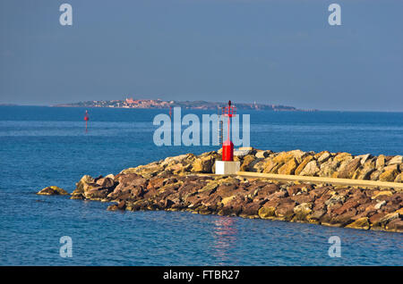 Red lighthouse at entrance to small ferry harbor in Sardinia Stock Photo