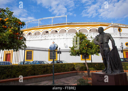 Curro Romero statue with ''Plaza de toros de la Real Maestranza de Caballería de Sevilla'' in the background. Andalusia, Spain. Stock Photo