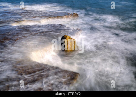 a rock in swirly water Stock Photo