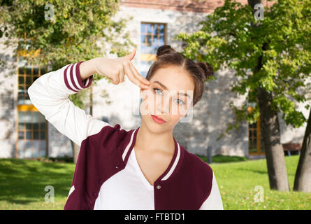 bored teenage girl making finger gun gesture Stock Photo