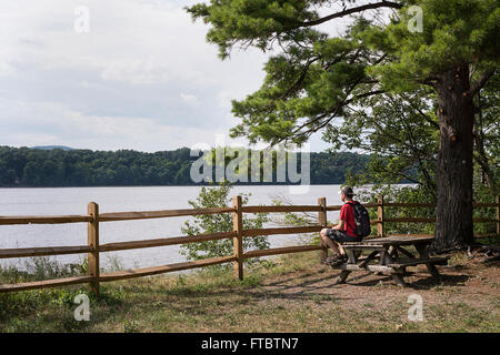 A man getting away from it all, sitting along the Hudson river in upstate New York Stock Photo