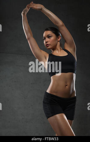 young woman posing and showing muscles in gym Stock Photo