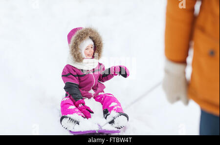 happy little kid on sled outdoors in winter Stock Photo