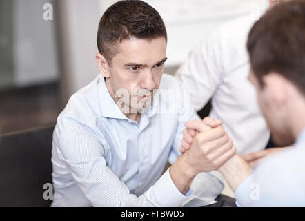 businessmen arm wrestling in office Stock Photo