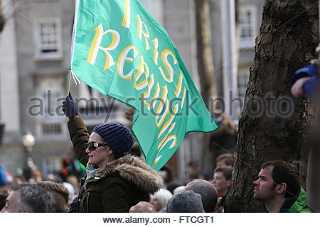 Dublin, Ireland. 27th March, 2016. A woman holds a green flag aloft during the parade in Dublin to celebrate the centenary of the 1916 Easter Rising. Credit:  reallifephotos/Alamy Live News Stock Photo