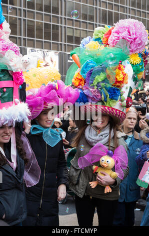 Women and girls wearing elaborate and brightly coloured head pieces at the 2016 Easter Bonnet parade and festival in New York. Stock Photo