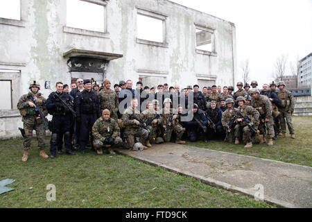 U.S. Marines with Alpha Fleet Anti-terrorism Security Team Company Europe (FASTEUR), Naval Station Rota and members of the Romanian Jandarmeria pose for a group photo at the conclusion of their training session at the Training Center of the Romanian Jandarmeria Special Intervention Brigade in Bucharest, Romania, Feb. 25, 2015. The Marines conducted training operations with host nation forces to support external security of U.S. Embassy Bucharest. (U.S. Marine Corps photo by Sgt. Esdras Ruano/Released) Stock Photo