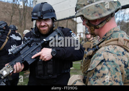 BUCHAREST, Romania (Feb. 26, 2015) U.S. Marine Lance Cpl. Christopher Rowe from Alpha Fleet Anti-terrorism Security Team Company Europe (FASTEUR), Naval Station Rota, explains the operation of an M27 automatic rifle to a member of the Romanian intelligence service at the Romanian intelligence service shooting range in Bucharest, Romania, Feb. 26, 2015. FASTEUR Marines conducted small arms marksmanship training with host nation forces during an embassy engagement to familiarize both forces on weapons normally used during security operations. (U.S. Marine Corps photo by Sgt. E Stock Photo