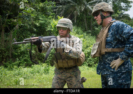 150314-N-JP249-058 ISSONGO, Cameroon (March 14, 2015) Marine Sgt. Benjamin Sheely, left, gives instructions to U.S. 6th Fleet Vice Commander Rear Adm. Tom Reck on how to fire an AK-47 assault rifle while on a firing range during Africa Partnership Stationon March 14, 2015, in Issongo, Cameroon. , Africa Partnership Station, an international collaborative capacity-building program, is being conducted in conjunction with a scheduled deployment by the Military Sealift Command’s joint high-speed vessel USNS Spearhead (JHSV 1). (U.S. Navy photo by Mass Communication Specialist 2nd Class Kenan O’Con