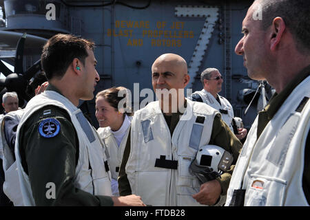 150402-N-GR120-499 MEDITERRANEAN SEA (April 02, 2015) - Lt. Ariel Klainerman, assigned to the Knighthawks of Strike Fighter Attack Squadron (VFA) 136, discusses flight operations with distinguished visitors during an air power demonstration on the flight deck of the Nimitz-class aircraft carrier USS Theodore Roosevelt (CVN 71) April 02, 2015. TR hosted members of the Israeli and Cyprus government and military as part of the Distinguished Visitors program. Theodore Roosevelt deployed from Norfolk and will execute a homeport shift to San Diego at the conclusion of deployment. Theodore Roosevelt  Stock Photo