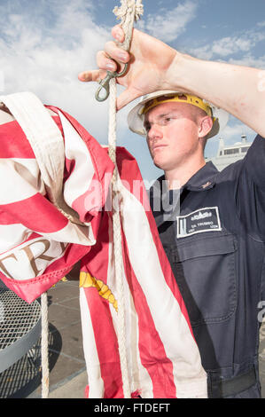 150703-N-XG464-039 MARSEILLE, France (July 3, 2015) - Hospital Corpsman 2nd Class Tyler Trumbo, from Orange, California, assigned to the amphibious transport dock ship USS New York (LPD 21), lowers the Navy jack in preparation for the ship pulling out of Marseille, France, July 3, 2015. USS New York, deployed as part of the Iwo Jima Amphibious Ready Group/24th Marine Expeditionary Unit, is conducting naval operations in the U.S. 6th Fleet area of operations in support of U.S. national security interests in Europe. (U.S. Navy photo by Mass Communication Specialist 3rd Class Jonathan B. Trejo/Re Stock Photo