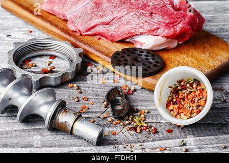 Raw beef on chopping board and kitchen utensils Stock Photo