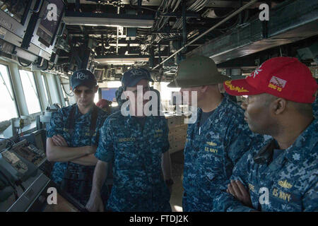 151120-N-TC720-339 ROTA, Spain (Nov. 20, 2015) Cmdr. Charles Hampton, commanding officer of USS Donald Cook (DDG 75), second from right, and Cmdr. Timothy Moore, executive officer of USS Donald Cook, right, speak with Lt. j.g. Fred Hendericks III, the ship’s navigator, second from left, as the ship pulls into Rota, Spain, to conclude its third forward deployed patrol Nov. 20, 2015. Donald Cook, an Arleigh Burke-class guided-missile destroyer, forward deployed to Rota, Spain is concluding a routine patrol in the U.S. 6th Fleet area of operations in support of U.S. national security interests in Stock Photo