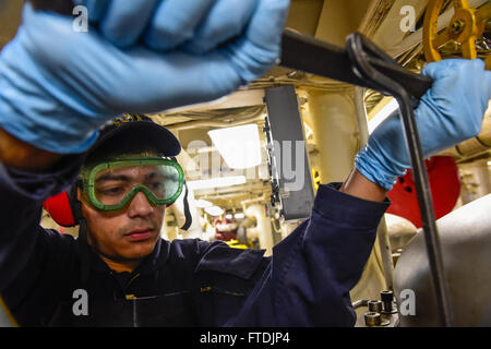 151211-N-FP878-101 AEGEAN SEA (Dec. 11, 2015) Gas Turbine Systems Technician (Mechanical) 3rd Class Erik Esquivel from Los Angeles, removes bolts from a filter separator during routine maintenance aboard USS Carney (DDG 64) Dec. 11, 2015. Carney, an Arleigh Burke-class guided-missile destroyer, forward deployed to Rota, Spain, is conducting a routine patrol in the U. S. 6th Fleet area of operations in support of U.S. national security interests in Europe. (U.S. Navy photo by Mass Communication Specialist 1st Class Theron J. Godbold/Released) Stock Photo