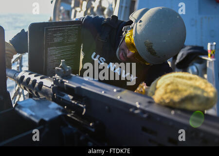 Fire Controlman 1st Class Carlos Grant, from Basin, Mississippi, performs maintenance on a .50 caliber machine gun aboard the USS Carney (DDG 64). The Arleigh Burke-class destroyer is operating in the Mediterranean Sea to support U.S. national security interests in Europe. Stock Photo
