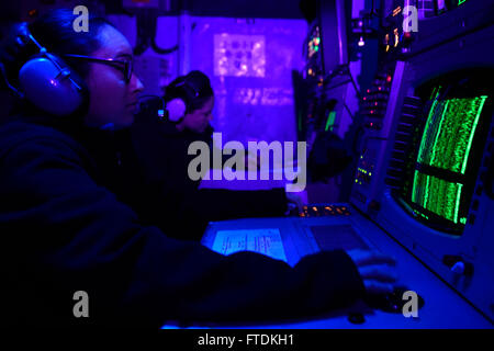 This image captures Sonar Technician Amy Palmer aboard the USS Carney, a guided-missile destroyer. The photo highlights her role in the sonar control room during a routine patrol in the Mediterranean Sea. Stock Photo