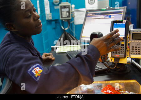 160126-N-FP878-081 MEDITERRANEAN SEA (Jan. 26, 2016) Ship’s Serviceman Seaman Gloria Crentsil, from Bronx, New York, completes a transaction in the ship’s store aboard USS Carney (DDG 64) Jan. 26, 2016. Carney, an Arleigh Burke-class guided-missile destroyer, forward deployed to Rota, Spain, is conducting a routine patrol in the U. S. 6th Fleet area of operations in support of U.S. national security interests in Europe. (U.S. Navy photo by Mass Communication Specialist 1st Class Theron J. Godbold/Released) Stock Photo