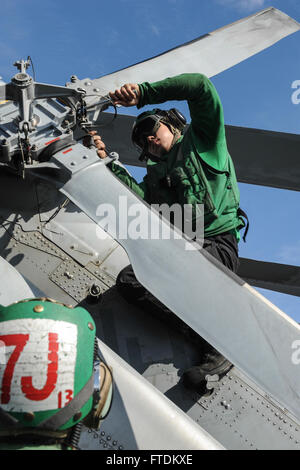MEDITERRANEAN SEA (Oct. 21, 2013) Aviation Machinist’s Mate Airman Christopher McCarthy, assigned to the Wolf Pack of Helicopter Maritime Strike Squadron (HSM) 75, performs maintenance on an MH-60R Seahawk helicopter on the flight deck of the aircraft carrier USS Nimitz (CVN 68). Nimitz is deployed supporting maritime security operations and theater security cooperation efforts in the U.S. 6th Fleet area of responsibility. (U.S. Navy photo by Mass Communication Specialist Seaman Apprentice Kelly M. Agee/ Released) Stock Photo