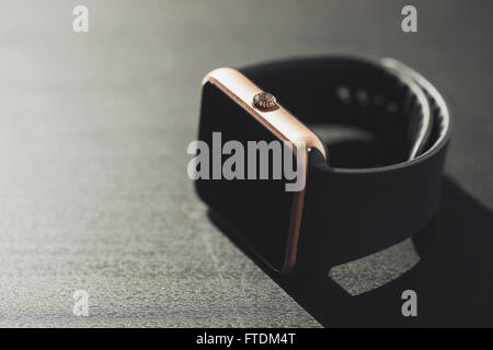 Smart watch shot in macro on the table. Fading film colors. Copy space on the left for text Stock Photo