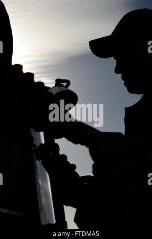 Fire Controlman 2nd Class Tyler Luckman performs post-fire checks on the close-in weapons system aboard the USS Carney (DDG 64) on February 12, 2016. The Arleigh Burke-class guided-missile destroyer, stationed in Rota, Spain, is deployed on a routine patrol in the U.S. 6th Fleet area, supporting U.S. national security interests in Europe. Stock Photo