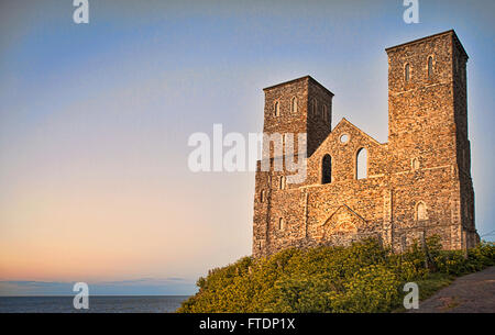 The imposing twin towers and remains of 12C  Reculver Towers and Roman Fort on  a grassy slope overlooking Herne Bay in Kent Stock Photo
